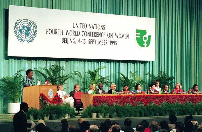 Gertrude Mongella (left, standing at the podium), Secretary-General of the Conference, addresses the session on 04 September 1995.  Photo: UN Photo/Milton Grant